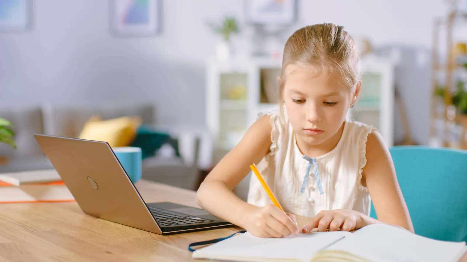 A child studying Russian online at home with a laptop and notebook