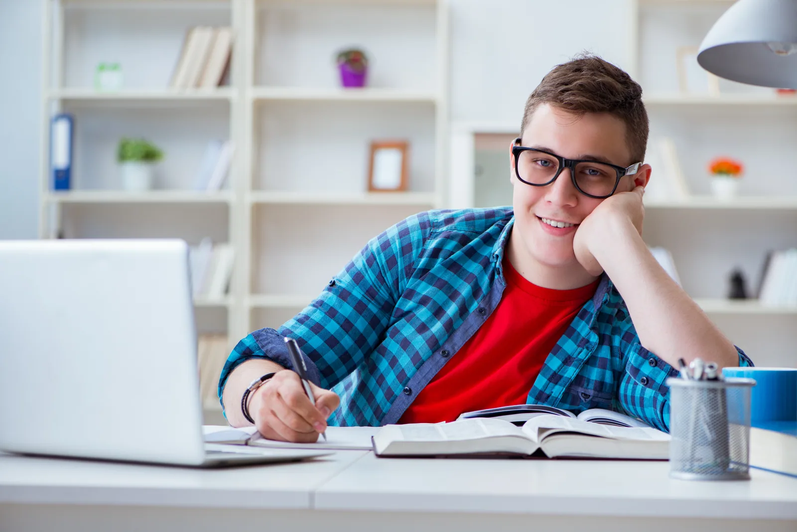 A teenage student preparing for exams at a desk with a laptop