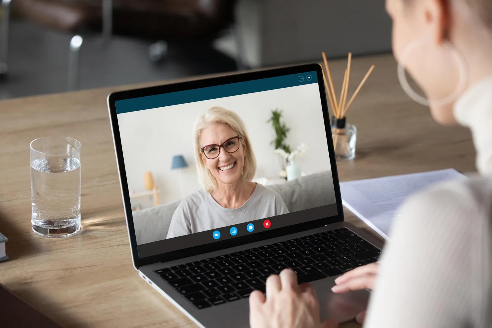 An adult learner speaking with a teacher on a laptop video call
