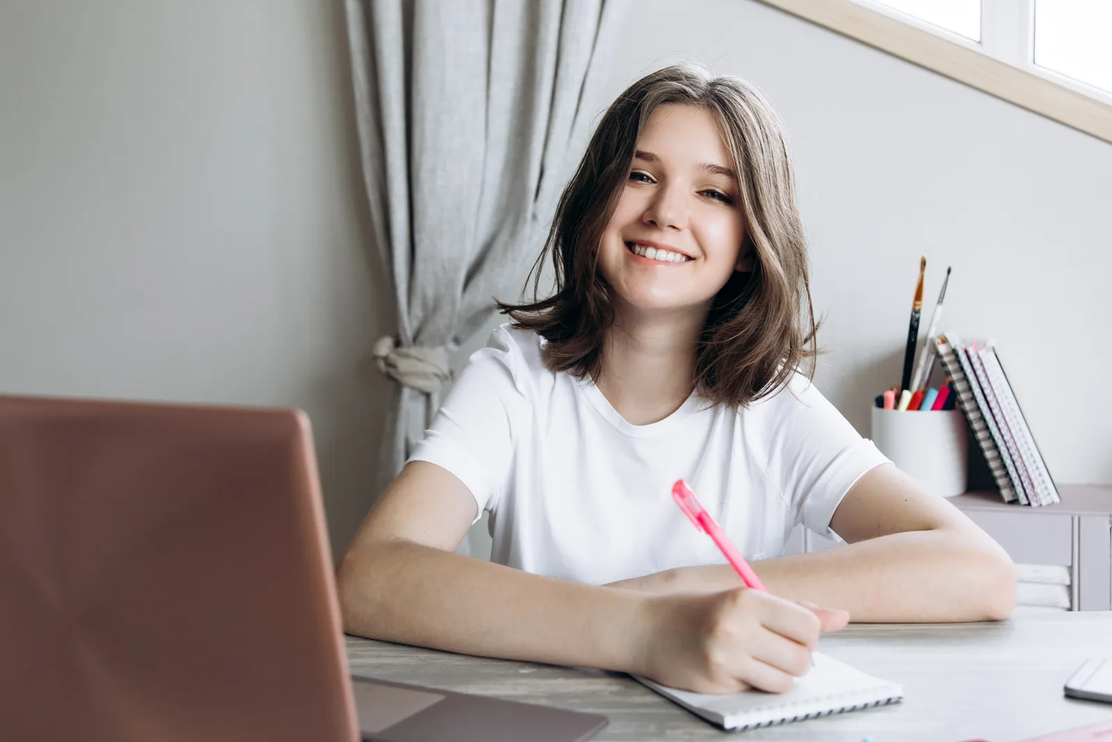 A teenage student doing homework on a laptop